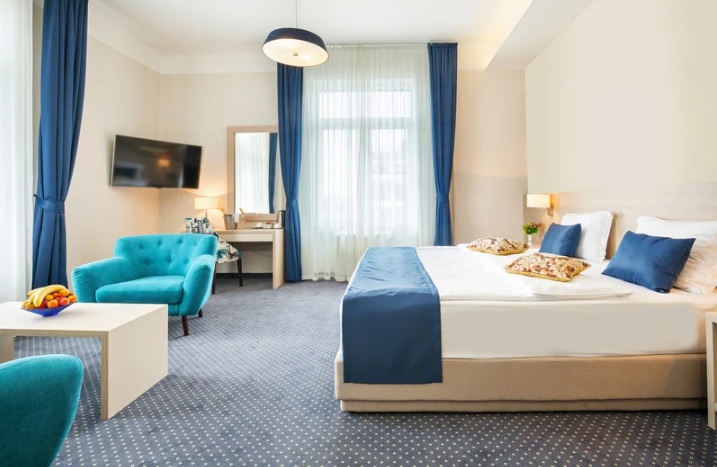 camera hotel con tonalità blu e neutre